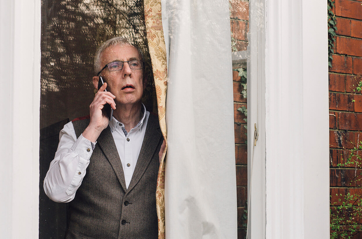 Man talking on the telephone while looking out of the window