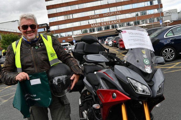 A Pick Up and Deliver volunteer outside York Hospital with his motorbike