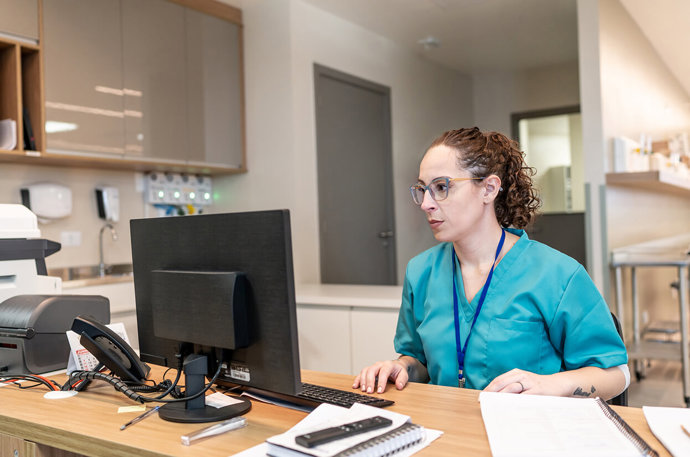 A medical professional looking at a screen 