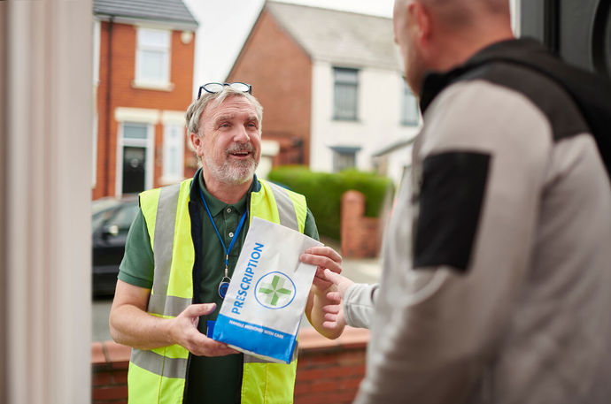 A Volunteer Responder delivering a prescription to someone at their home