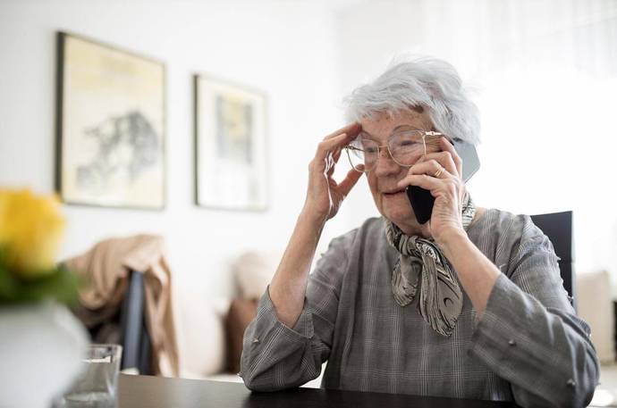 An older woman on the phone recieveing a phone call