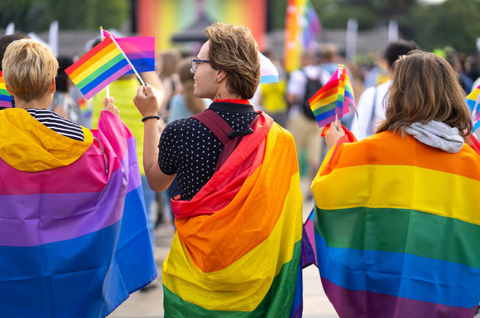 A group of people wearing pride flags
