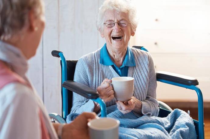two women having a conversation while having a cup of tea 