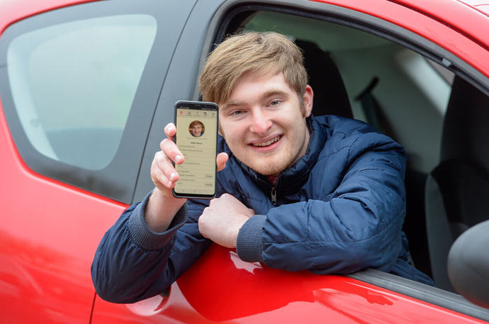 A Volunteer Responder in his car holding up his phone