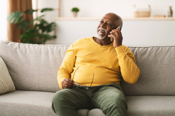 A man sitting on a sofa and having a conversation on a mobile phone