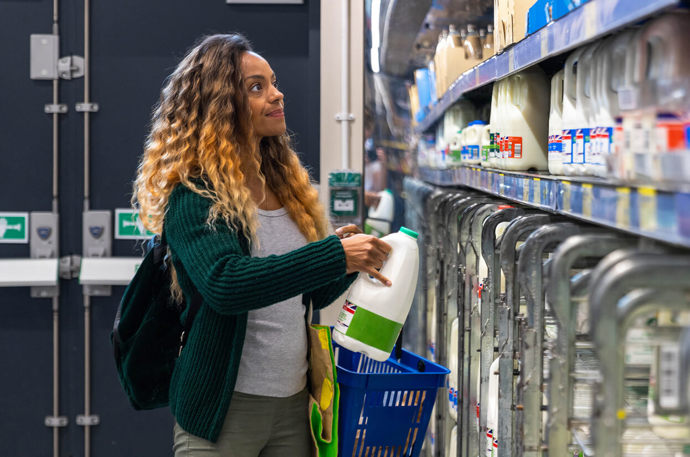 A female volunteer picking up some essential items from the supermarket to take to a client 