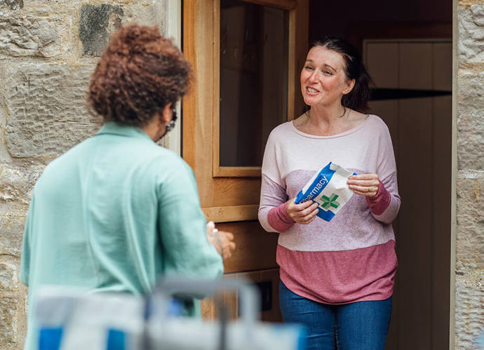 A woman receiving a prescription delivery at her home 