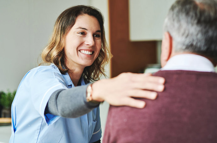 A medical professional with their arm around a patient