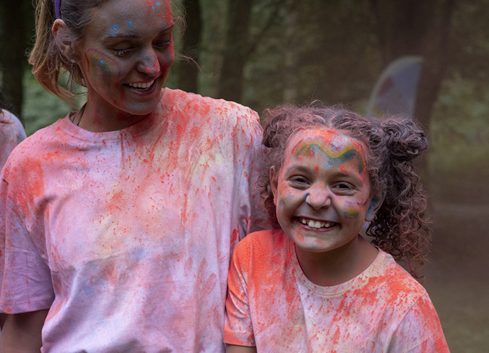 A woman and child celebrating Holi covered in colours